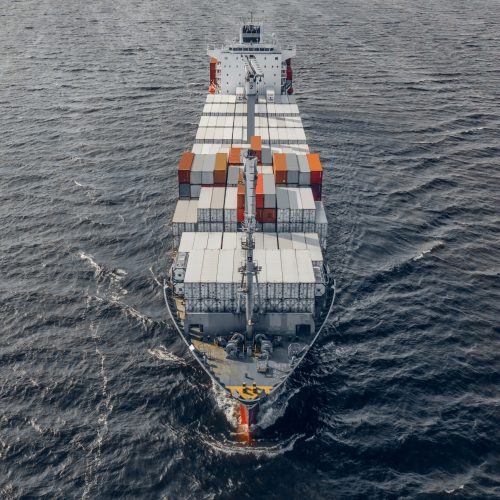 Aerial view of container ship floating in the sea. Square format